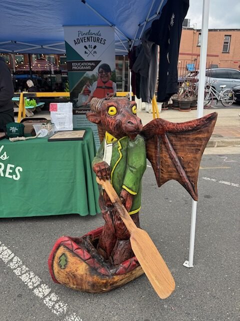 Jersey Devil carving and vendor display at the Jersey Devil Fable Festival.
