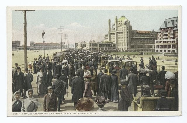 Crowd on Atlantic City boardwalk, historic New Jersey scene and architecture.